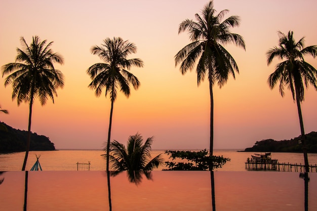 Заход солнца отражая на переднем плане поверхности воды с зоной кокосовых пальм ao bang bao на Koh Kood.