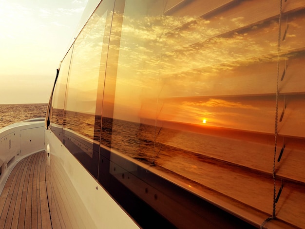 Photo sunset reflection on boat in sea