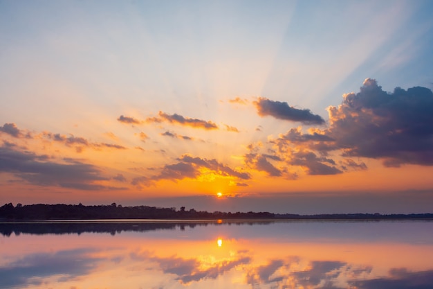 写真 日没の反射ラグーン。オーバーラグーンの風景の上の雲と青空の背後にある美しい夕日