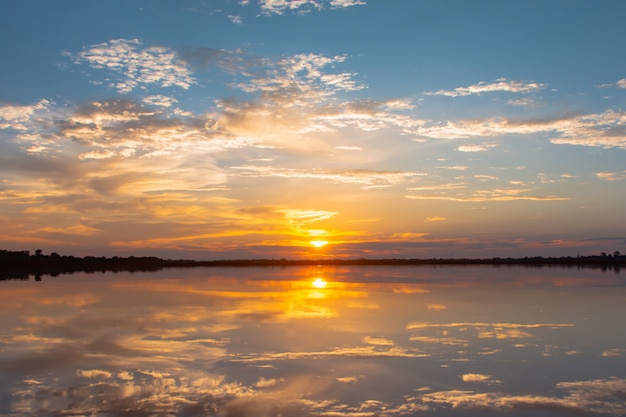 Tramonto riflesso laguna. bel tramonto dietro le nuvole e il cielo blu sopra il paesaggio lagunare. cielo drammatico con nuvole al tramonto