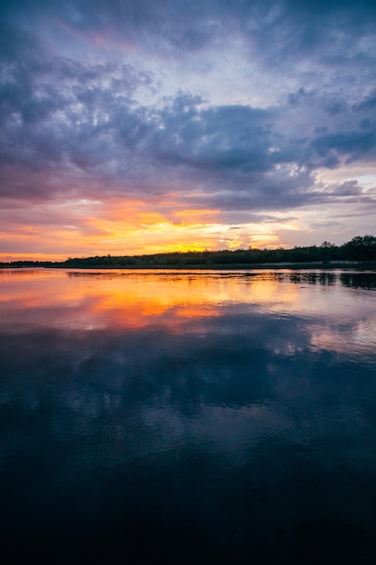 Sunset over a river with an orange sky on horizon