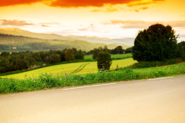 Sunset road with Norway hills on background