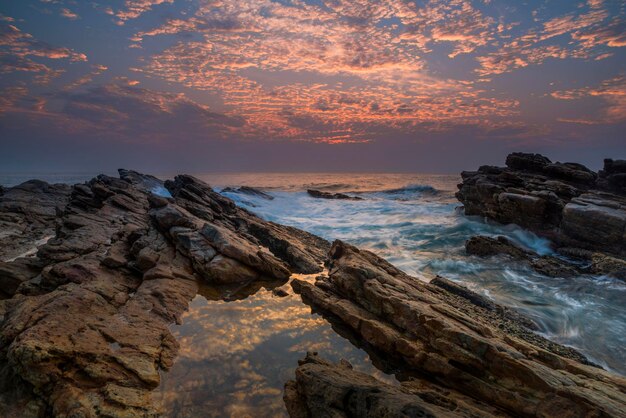 Sunset on the rocky shore of a tropical island