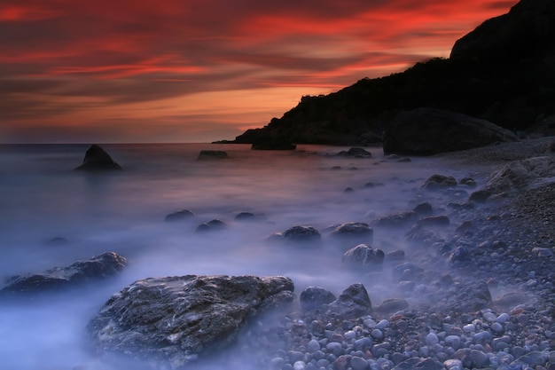 Sunset on the rocky shore of tropical sea Summer vacation on tropical resort