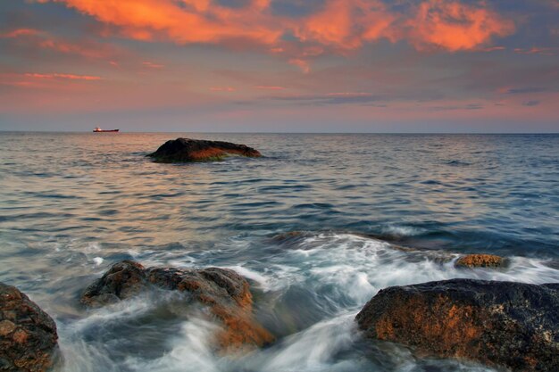 Sunset on the rocky shore of tropical sea