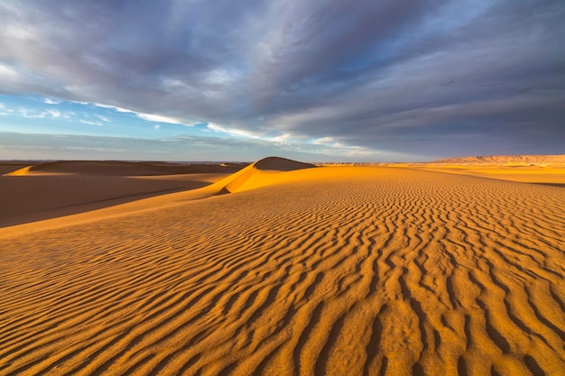 Sunset over the sand dunes in the desert Arid landscape of the Sahara desert