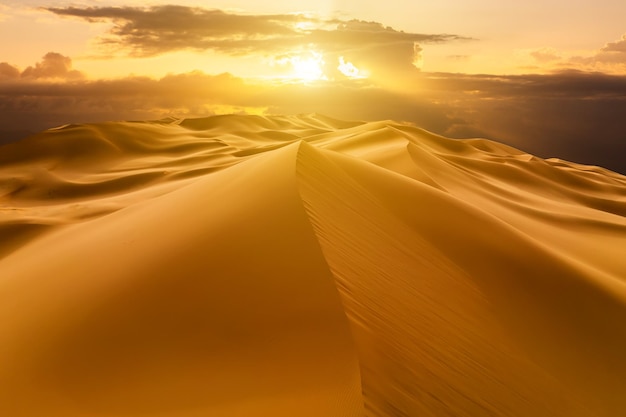 Sunset over the sand dunes in the desert Arid landscape of the Sahara desert