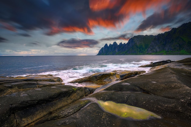 Закат над живописными скалами пляжа тунгенесет на острове сенджа в норвегии