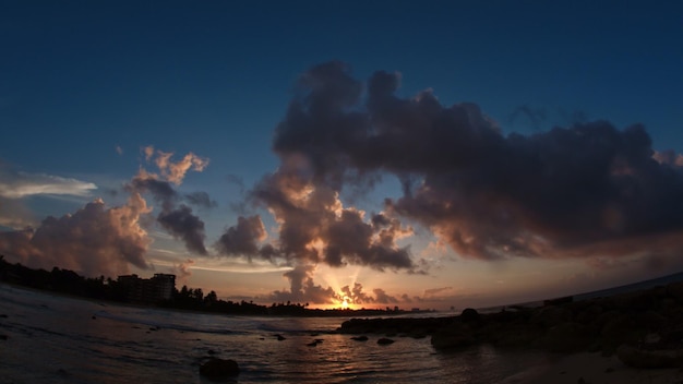 Sunset over sea - caribbean tropical waterfront in clouds, wide angle