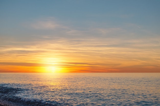 Foto tramonto sull'orizzonte del mare. il sole tramonta sul mare. alla fine della giornata, è tempo di riposarsi e rilassarsi.