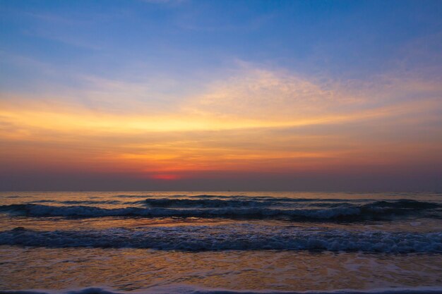 Sunset over sea majestic clouds in the sky at coastline