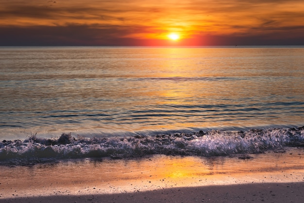 Sunset and the sea in orange dark sky.