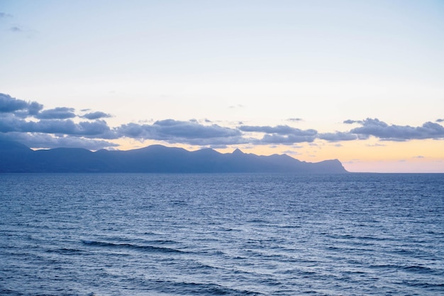 Sunset on sea Rays of setting sun between clouds above sea surface Meditation and relaxation Tourism and travel