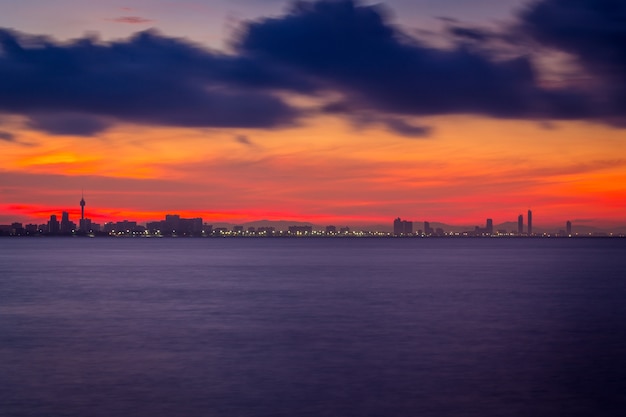 Sunset on the sea. Silhouette of city