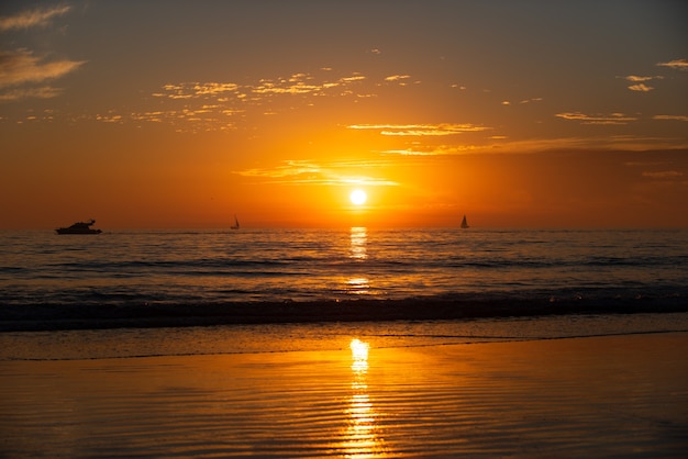 ビーチでの海の日の出の夕日カラフルな海のビーチの日の出