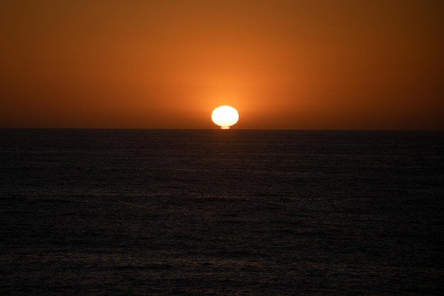 海に沈む夕日。ビーチの日の出。カラフルな海、コピースペースと自然の風景の背景。