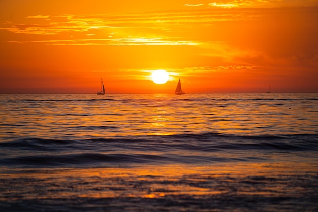 コピースペースとビーチのカラフルな海の自然の風景の背景に海の日の出の夕日