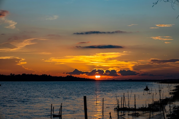 A sunset over the sea with a few clouds