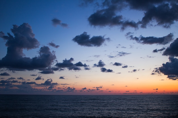 劇的な空とカラフルな雲と夕日の海