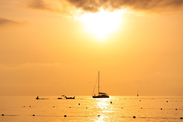 海岸に沈む夕日美しい夕日を背景にしたヨットのシルエット