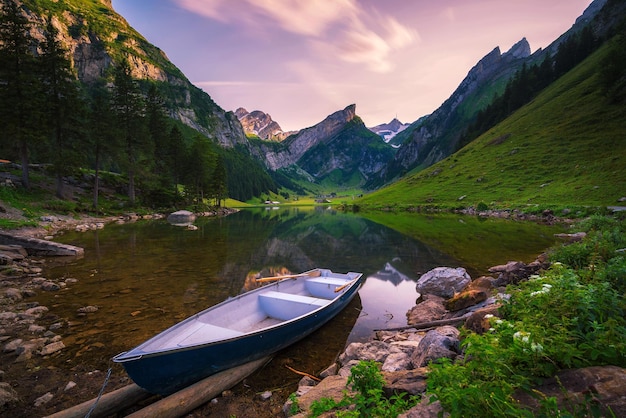 Sunset over the seealpsee lake with a boat in the swiss alps switzerland