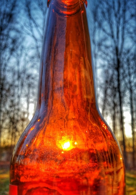 Foto il tramonto visto attraverso una bottiglia di birra