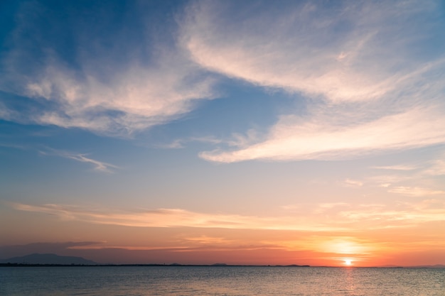 カラフルな日没のオレンジ色の日光、夕暮れの空と夕方の海に沈む夕日。