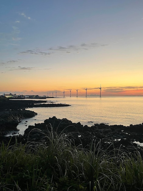 写真 日没の空 海と風力発電機 バザルトと海