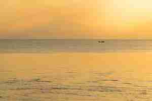 Photo sunset sky over sea in the evening and fishing boat minimallism