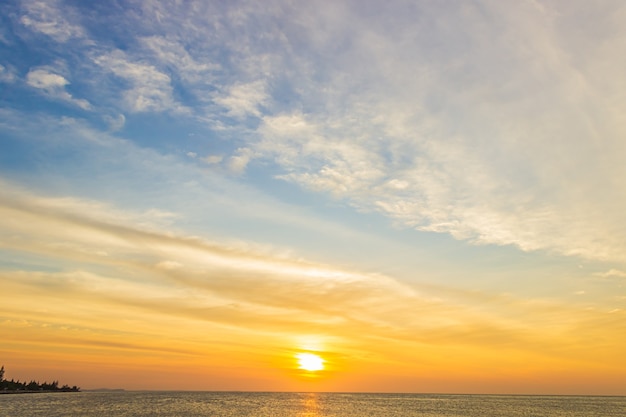 カラフルな雲オレンジ色の日光と夕方の海に沈む夕日