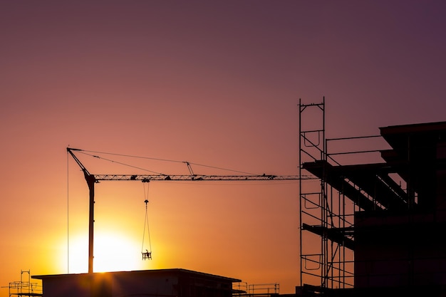 Sunset sun dawn at Construction site building crane technology