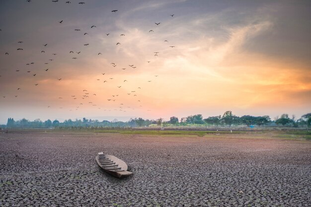 Sunset or sunrise with arid land and fishing boat