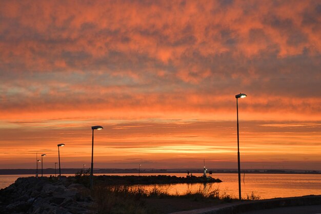 Sunset in Sweden at the harbor of lake Vaettern Lighthouse in the background