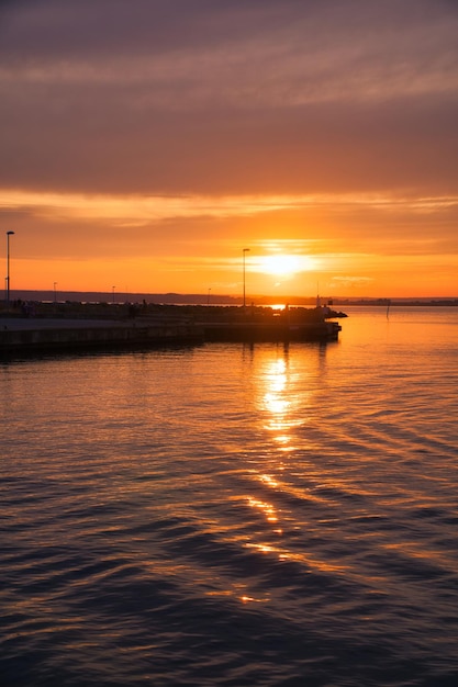 バック グラウンドで湖 Vaettern 灯台の港でスウェーデンの夕日