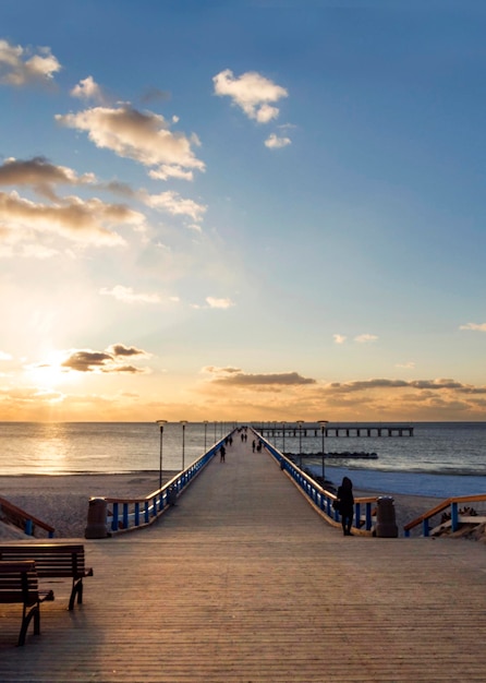 Sunset and vacationers on the bridge of Palanga on the Baltic Sea in Klaipeda Lithuania