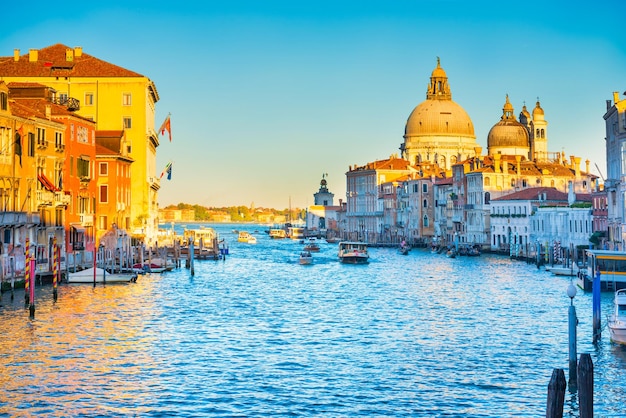 Sunset view of Grand Canal with boats and Basilica Santa Maria della Salute Venice Italy