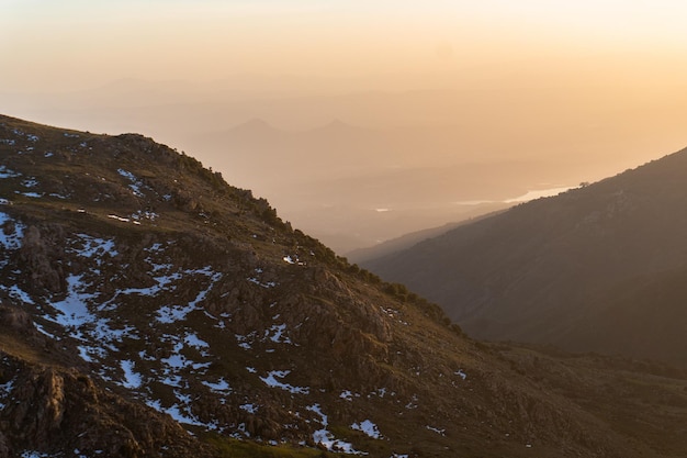 Foto una vista al tramonto delle montagne dalla cima della montagna.