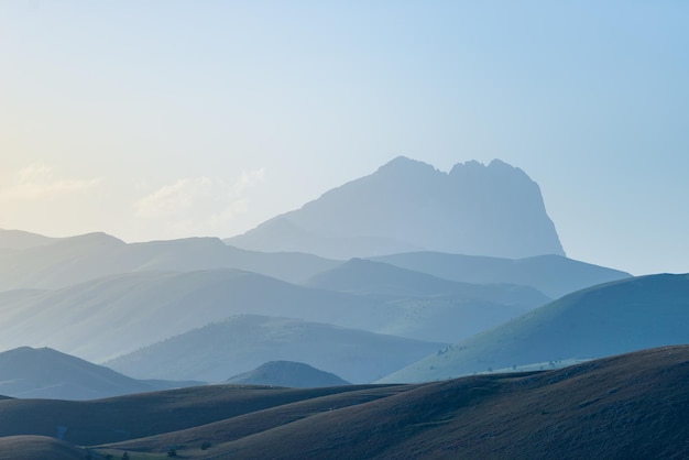 Punto di vista tramonto sulla silhouette di montagne rocciose campo imperatore appennino del gran sasso italia il sole del cielo limpido esplose sul drammatico crinale della montagna