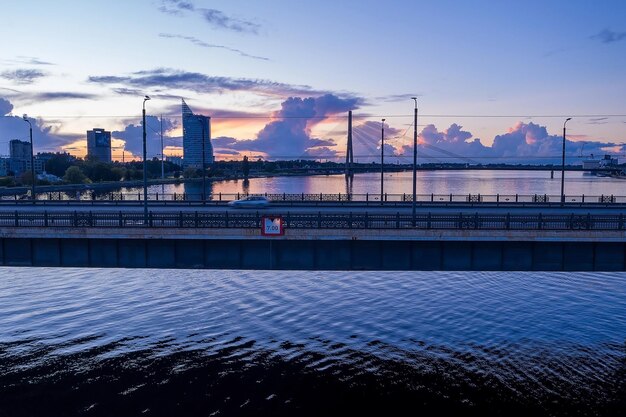 ラトビア、リガのダウガヴァ川に架かる交通橋の夕日の眺め。