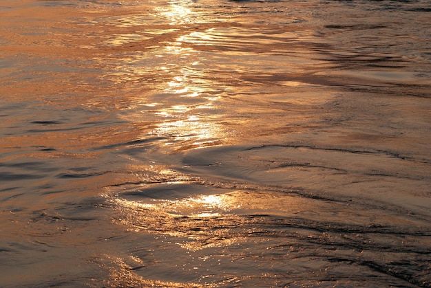 太陽の線のある夕日の水は背景に使用できます