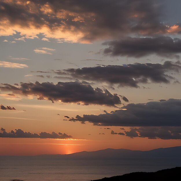 a sunset with clouds and mountains in the background