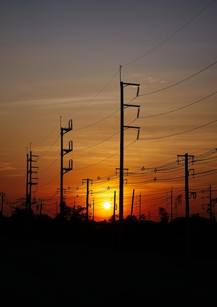 Foto un tramonto con linee elettriche e linee elettriche