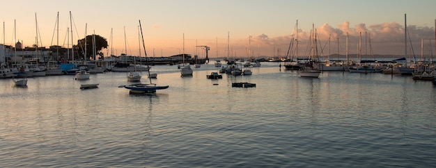 Sunset with sailboats anchored at the edge of the Ribeira in Salvador Bahia Brazil.