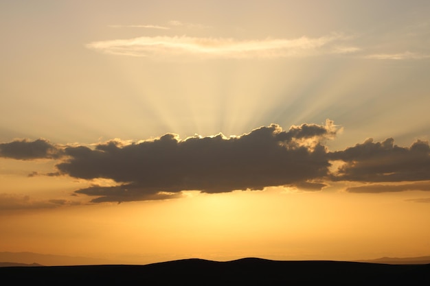 A sunset with the sun setting behind the clouds