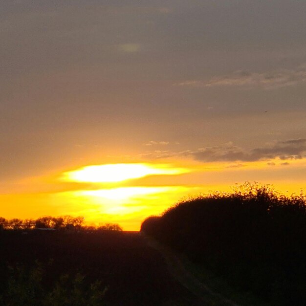 A sunset with a yellow sky and a few clouds