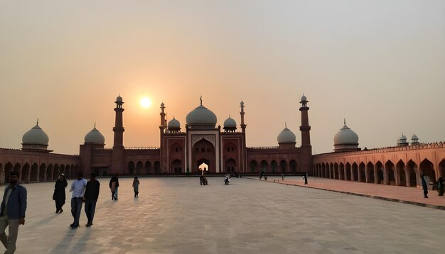 sunsets casting a warm glow on the badshahi masjid lahore