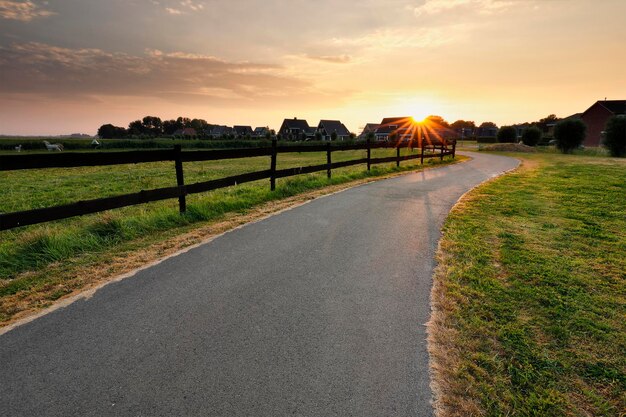 sunshine over cycling path by wooden fence