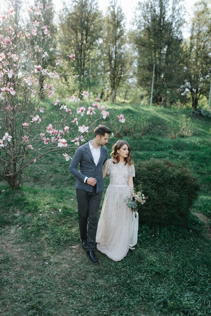 Sunshine portrait of happy bride and groom outdoor in nature location at sunset. Warm summertime