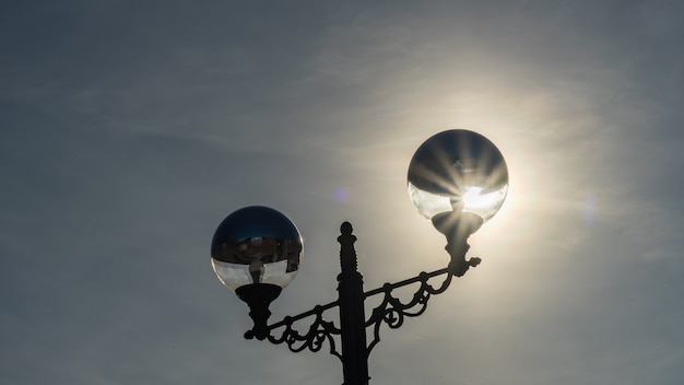 Foto sole dietro luce stradale sullo sfondo del cielo. soci, russia.