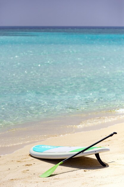 Sup Board on sandy beach in Maldives with writing I love Gulhi